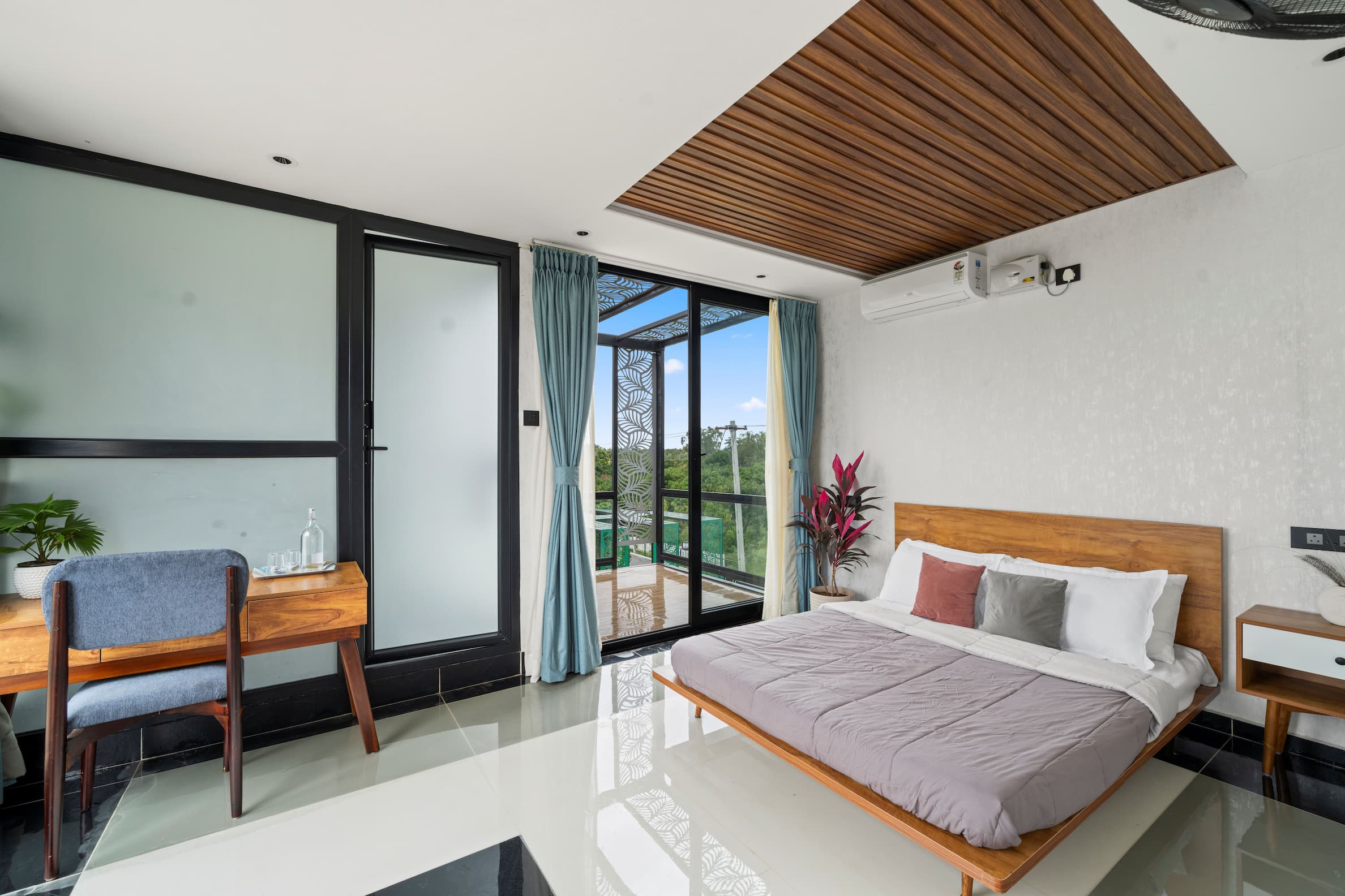 Second bedroom with wooden bed frame, balcony and nature views